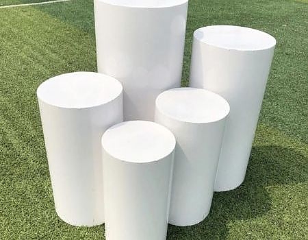 White cylinder objects on green grass at an outdoor event