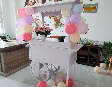 Cart decorated with balloons and flowers for a party