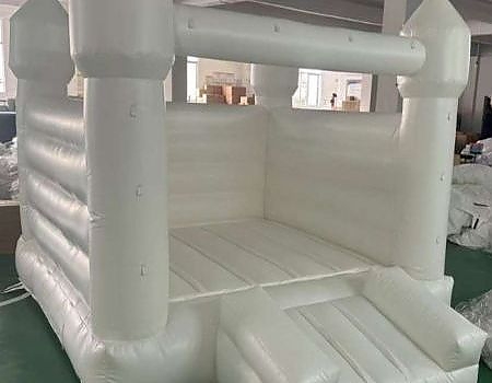 A white inflatable castle on green floor for an event