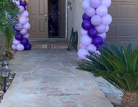 Door to a house decorated with purple balloons