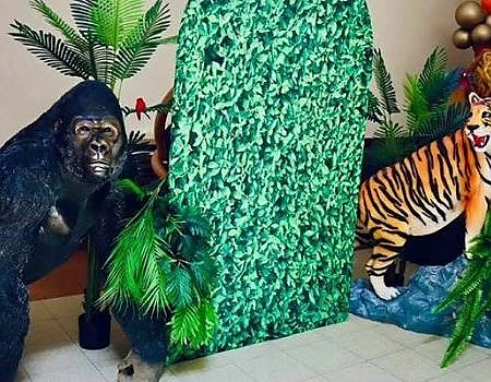 Gorilla and tiger statues at a green tree event setup